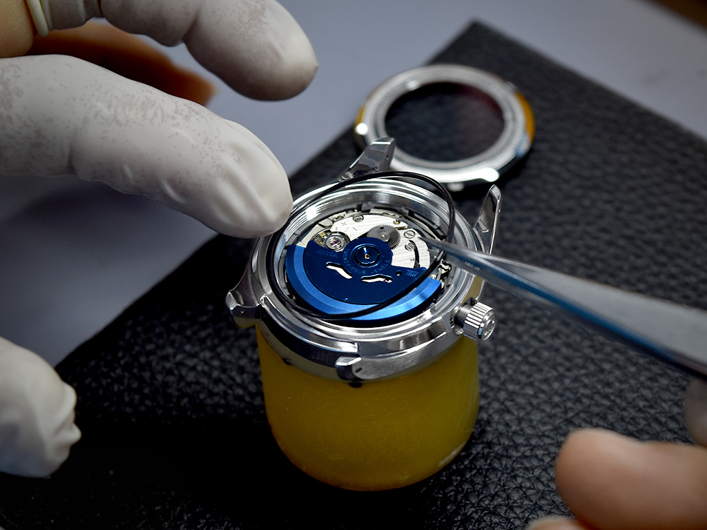 Finalising the whole case by inserting the gasket and screwing down the case-back.