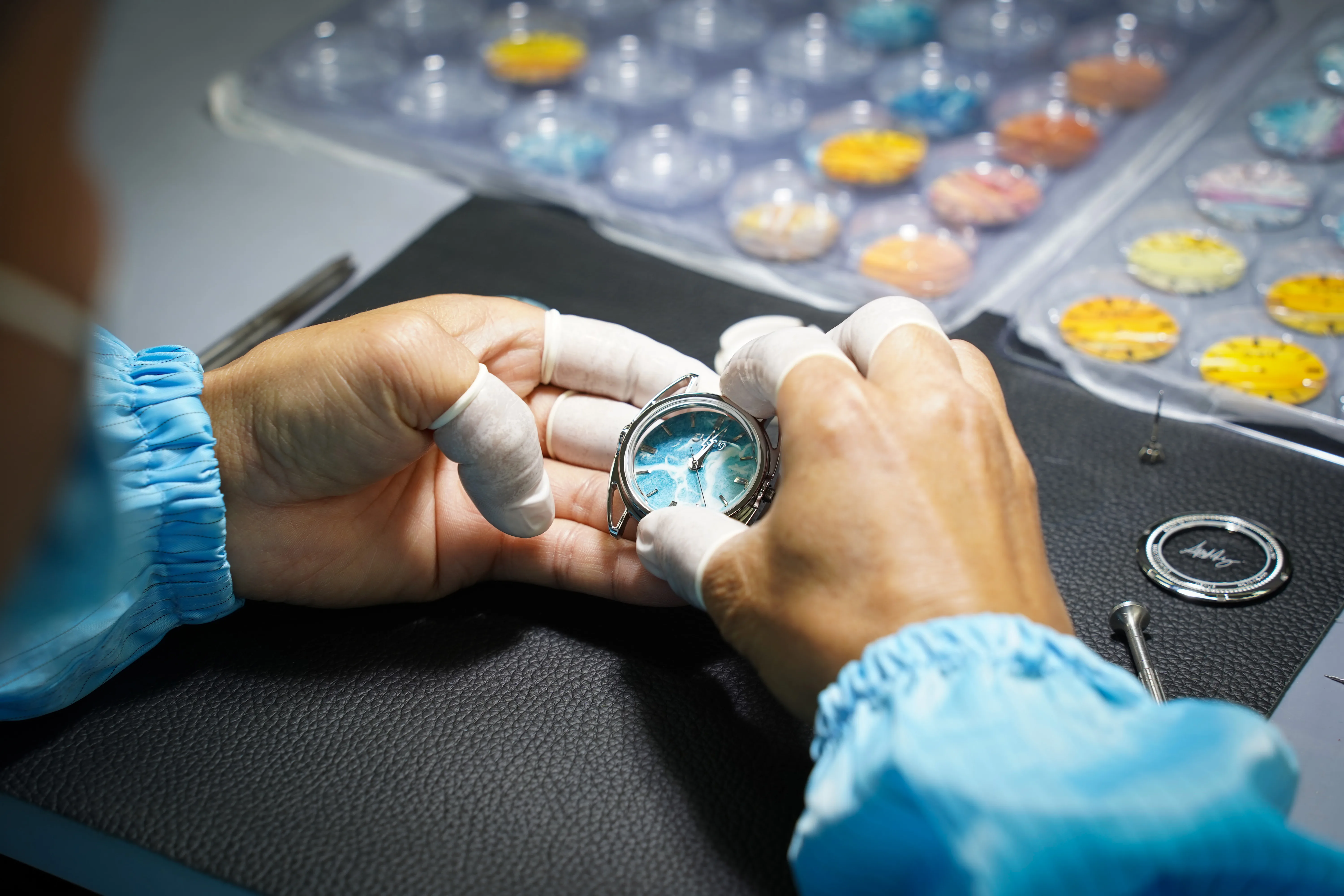 A Hitori craftsman setting a washi dial, a tray of finished dials beside him